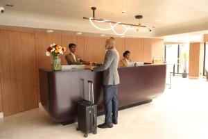 a man standing at a counter in an office at Hotel Palacio Paltan Bazaar in Guwahati
