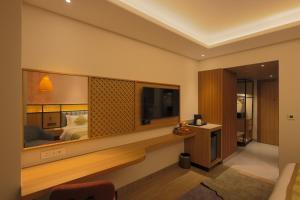 a hotel room with a television and a bed at Hotel Palacio Paltan Bazaar in Guwahati +52 photos