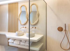 a bathroom with a sink and a mirror at EvMariA suites in Fira