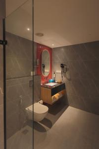 a bathroom with a toilet and a sink and a mirror at Hotel Palacio Paltan Bazaar in Guwahati