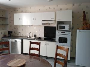 a kitchen with white cabinets and a table at le chêne in Créancey