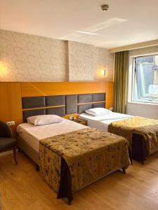 ein Hotelzimmer mit zwei Betten und einem Fenster in der Unterkunft ferhane hotel in Adana