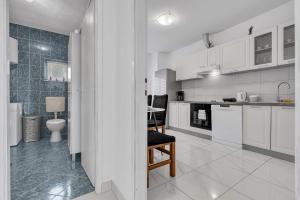 a kitchen with white cabinets and a table with a chair at Apartment Green Valley in Imotski +13 photos