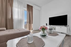 a living room with a couch and a tv at Apartment Green Valley in Imotski