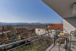 a balcony with a table and chairs and a view at Apartment Green Valley in Imotski