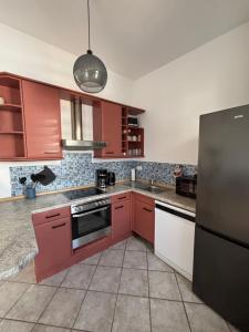 a kitchen with red cabinets and a black refrigerator at Altstadtgold in Rostock
