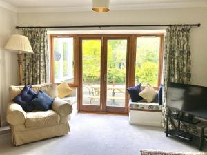 a living room with a sliding glass door to a patio at The Coach House in Saint Fillans
