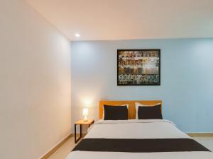 a bedroom with a bed and a painting on the wall at Super Townhouse Qualia Prime in Hyderabad