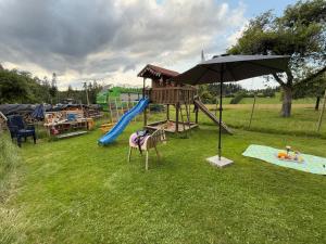 a playground with a slide and an umbrella at Tälealpakahof in Alpirsbach