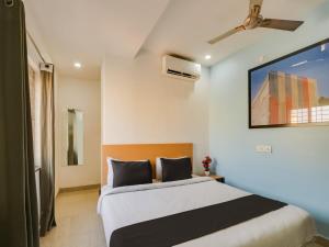 a bedroom with a bed and a ceiling fan at Super Townhouse Qualia Prime in Hyderabad