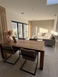 a living room with a wooden table and a couch at Casa Nova Arnhem in Arnhem +2 photos