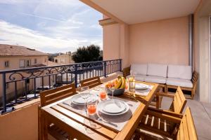 a dining table on a balcony with a view at Appartement neuf et moderne à Grimaud - Fééries Provençales 212 in Grimaud
