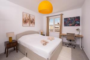 a bedroom with a bed with a desk and a chair at Appartement neuf et moderne à Grimaud - Fééries Provençales 212 in Grimaud +17 photos