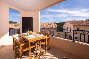 a balcony with a table and chairs on a balcony at Appartement neuf et moderne à Grimaud - Fééries Provençales 212 in Grimaud