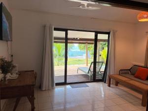 a living room with a sliding glass door to a patio at Beach House Beau Vallon in Beau Vallon