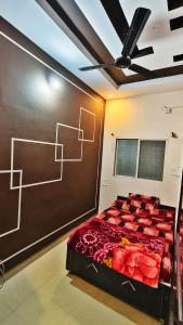 a bed in a room with a painting on the wall at Adiyogi Guest House in Ujjain