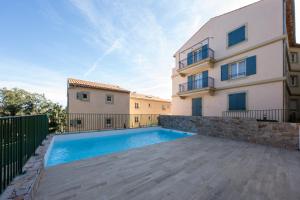 a villa with a swimming pool in front of a building at Appartement neuf et moderne à Grimaud - Fééries Provençales 212 in Grimaud