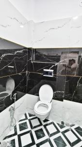 a black and white bathroom with a toilet at Adiyogi Guest House in Ujjain