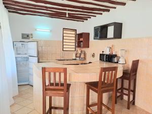 a kitchen with two chairs and a table with a counter at Elna's Haven Diani Palms - 5min walk to the beach, serene and culinary services in Ukunda