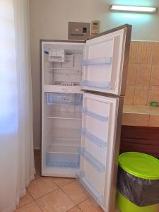 an empty refrigerator with its door open in a kitchen at Elna's Haven Diani Palms - 5min walk to the beach, serene and culinary services in Ukunda +31 photos