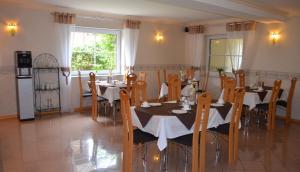 a dining room with tables and chairs and a window at Hotel Messeblick in Sarstedt