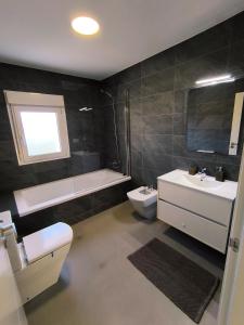 a bathroom with a sink and a toilet and a bath tub at Atico Deluxe en Vimianzo in Toja +12 photos