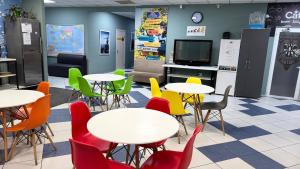 a cafeteria with tables and chairs and a tv at Hostel City Center in Chişinău
