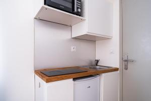 a small kitchen with a sink and a microwave at High Five - Chambre Calme Sur Les Ramblas in Toulouse +3 photos