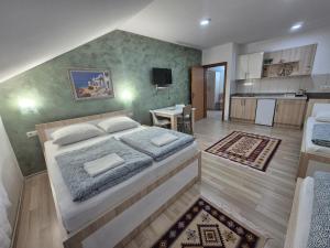 a bedroom with a large bed and a kitchen at Apartments City Paradise in Mostar