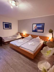 a hotel room with two beds and two tables at Hotel Messeblick in Sarstedt