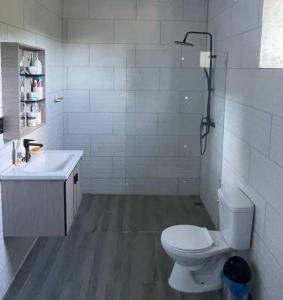 a white bathroom with a toilet and a sink at Xamanai Playa Rincón in Castellalito +8 photos