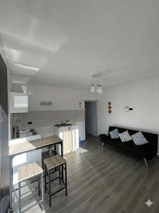 a living room with a black couch and a kitchen at Xamanai Playa Rincón in Castellalito