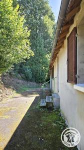a building with two benches on the side of it at gite bertry in Eyburie