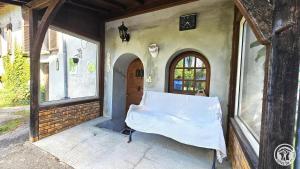 a porch of a house with a bed in it at gite bertry in Eyburie