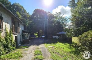 a dirt road with chairs and an umbrella in a yard at gite bertry in Eyburie