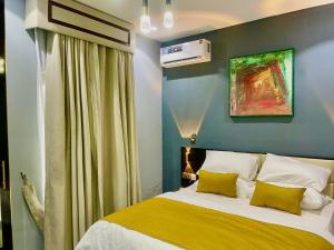 a bedroom with a bed with yellow and white pillows at GoodHouse XT in Lekki +32 photos
