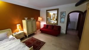 a bedroom with a bed and a red chair and a mirror at Traumhaus im Wald in Tutzing