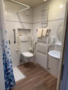 a bathroom with a toilet and a sink at Landhotel Franck Garni in Brietlingen +88 photos
