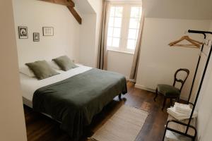 a bedroom with a bed and a chair and a window at ABBAYE DE BLANCHELANDE in Neufmesnil