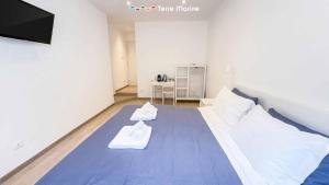 ein Schlafzimmer mit einem Bett, auf dem zwei Handtücher liegen in der Unterkunft Sapri 29, Terre Marine in La Spezia
