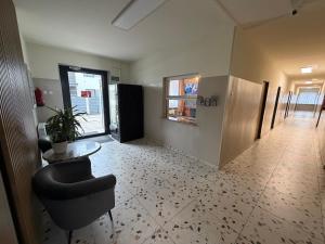 a hallway of an office with a table and a chair at Relaks Noclegi in Częstochowa +7 photos