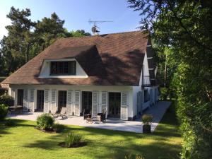 ein weißes Haus mit einem Schiebedach in der Unterkunft Villa d'hôtes Graine de Pin in Le Touquet-Paris-Plage