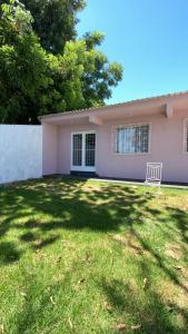 a pink house with a chair in the yard at Casa da Simonia in Foz do Iguaçu