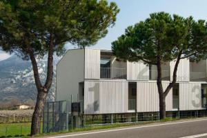 a building with trees on the side of a road at meckisapartment in Nago-Torbole
