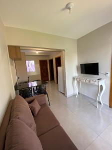 a living room with a couch and a table and a television at Casa da Simonia in Foz do Iguaçu