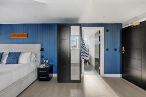 a bedroom with a bed and a blue wall at Provident Suite - Free Wi-Fi - Sea View in Brixham