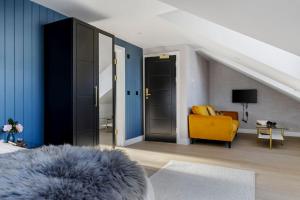 a living room with a yellow chair and blue walls at Provident Suite - Free Wi-Fi - Sea View in Brixham