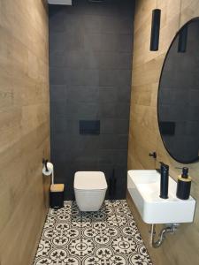 a bathroom with a white toilet and a sink at Baltic Park in Rozewie