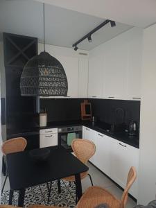 a kitchen with a black table and chairs in it at Baltic Park in Rozewie