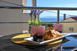 a table with a plate of bread and two glasses at apartmani sukošan in Sukošan